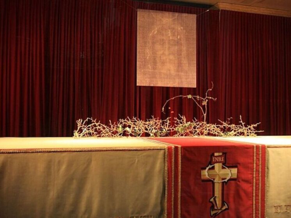 Алтарь с изображением Иисуса на фоне красного занавеса и венком терновника.