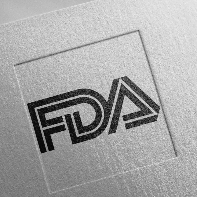 Логотип FDA на текстурированной бумаге, черно-белый дизайн с объемными буквами.