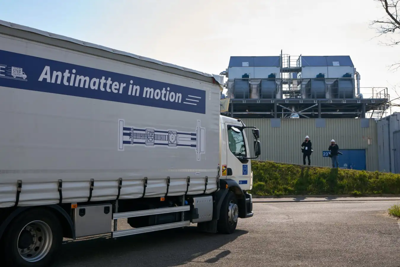 Грузовик с надписью "Antimatter in motion" на заводской территории, антиматерия в движении.