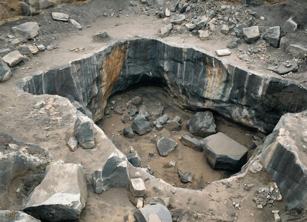 Карьера с гранитными обломками и каменными стенами, вид сверху.