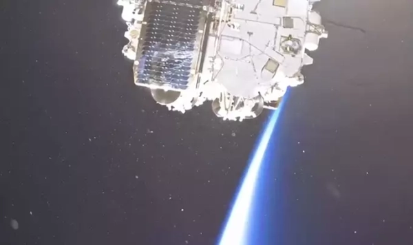 Космический аппарат в открытом космосе, вид Земли с ярким лучом света.