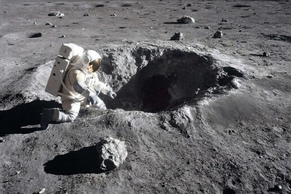 Астронавт исследует кратер на поверхности Луны в космическом костюме.