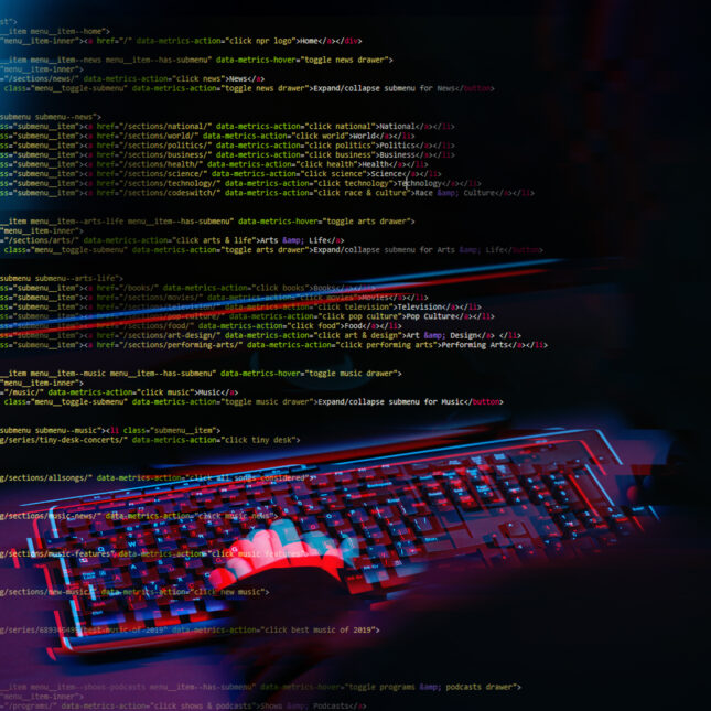 Код на экране и клавиатура в темной комнате, создающая атмосферу программирования.