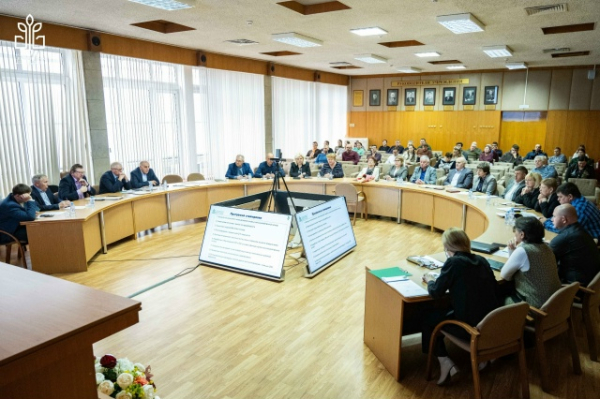 Конференция в зале, участники за круглым столом обсуждают презентации.