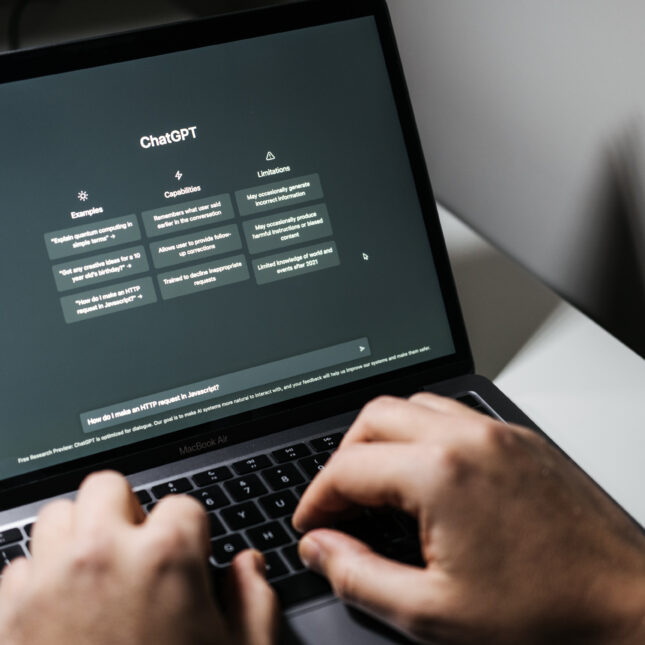 Руки на ноутбуке с открытым ChatGPT на экране.