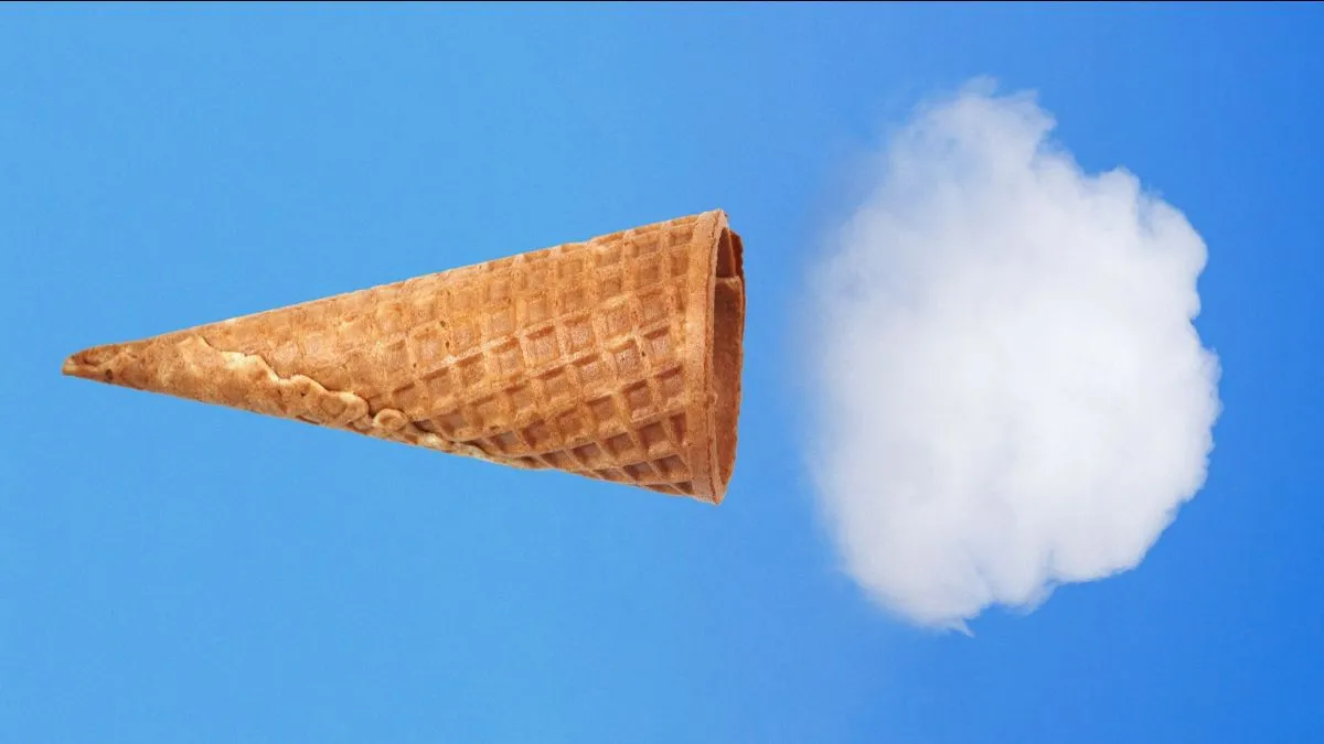 Вафельный конус выглядит как облако на фоне голубого неба, сочетание природы и фантазии.