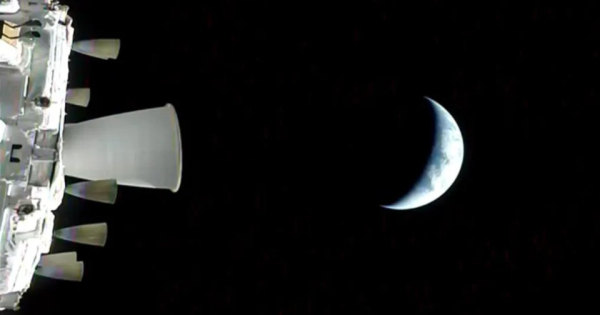 Космический аппарат на фоне Луны в фазе полумесяца в открытом космосе.