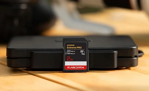 Карта памяти SanDisk Extreme PRO 2TB на столе перед черным кейсом.