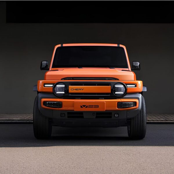 Оранжевый внедорожник Chery X23, вид спереди, на фоне бетонной стены.