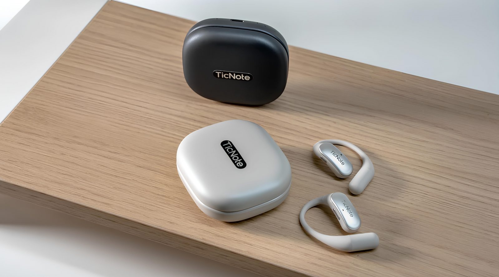 Беспроводные наушники и футляры TicNote на деревянной поверхности.