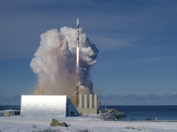 Запуск ракеты в зимнем пейзаже, дым и огонь вокруг.