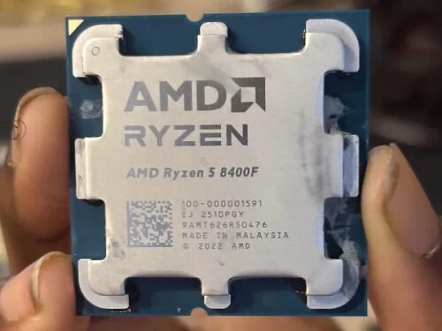 Процессор AMD Ryzen 5 8400F в руке, видна маркировка и детали корпуса.