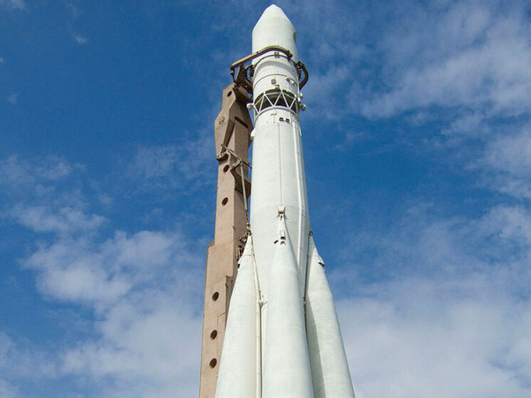 Белая ракета поднимается в небо на фоне облаков.