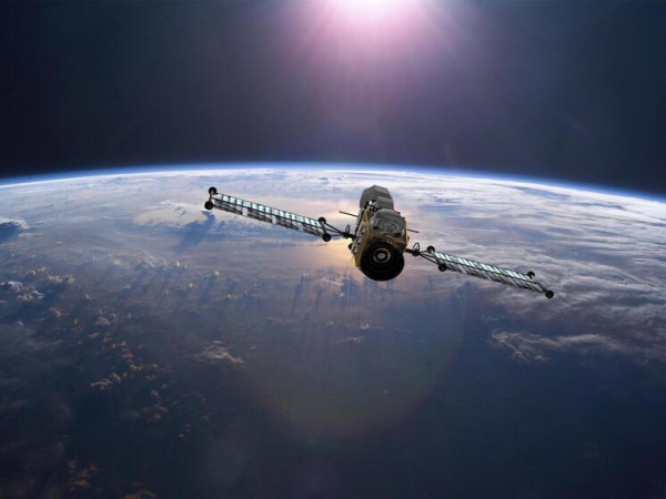 Спутник на орбите Земли, освещенный солнцем. Вид на планету из космоса.