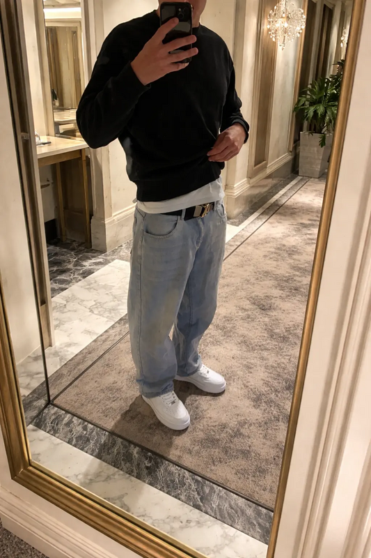 a man standing in front of a mirror taking a selfie with his cell phone