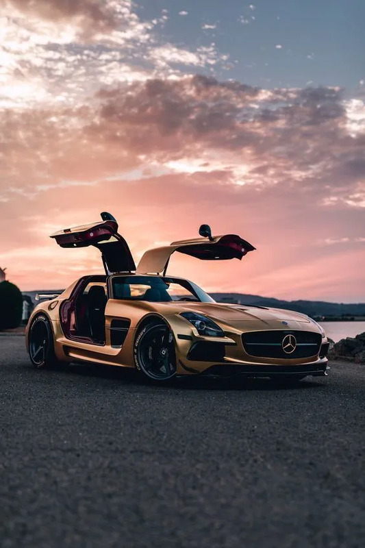 a man standing on top of a yellow sports car