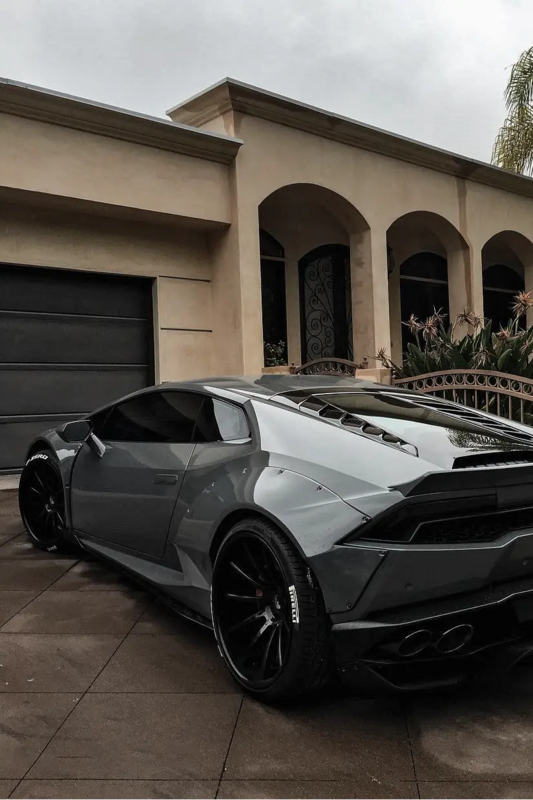 a black and silver sports car parked in front of a house