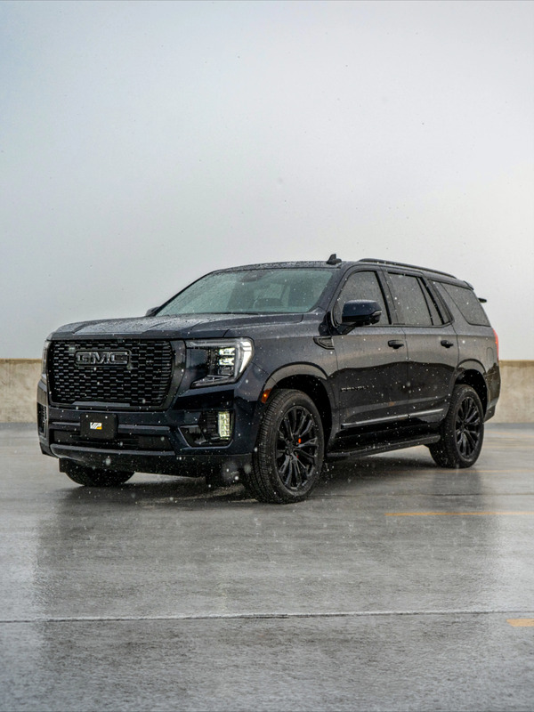 Custom dark blue Yukon Denali with black trim, black powder coat wheels, and tinted windows.