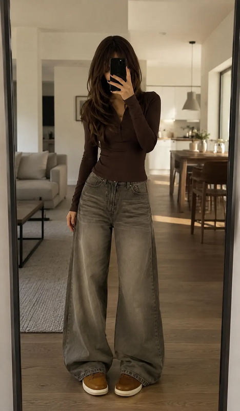 Mirror selfie featuring a woman wearing a fitted brown long sleeve top with oversized wide leg jeans for a casual everyday fashion look.