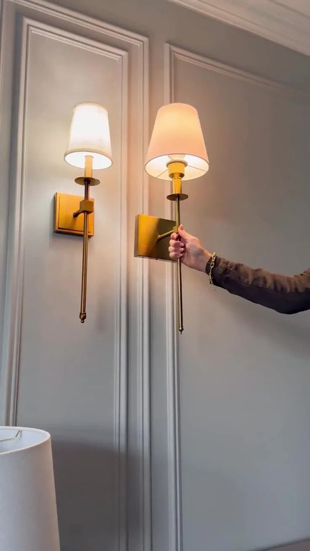 a man is holding the arm of a wall light