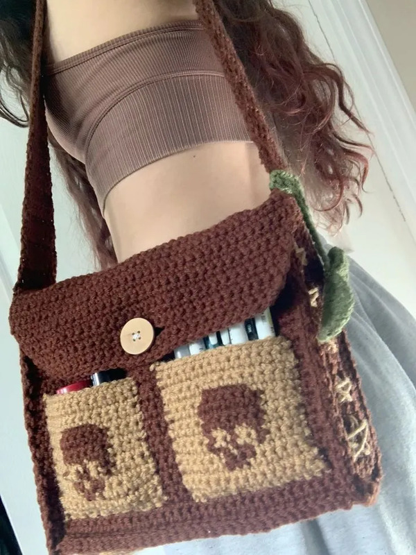 a woman is holding a crochet bag with an elephant on the front and side