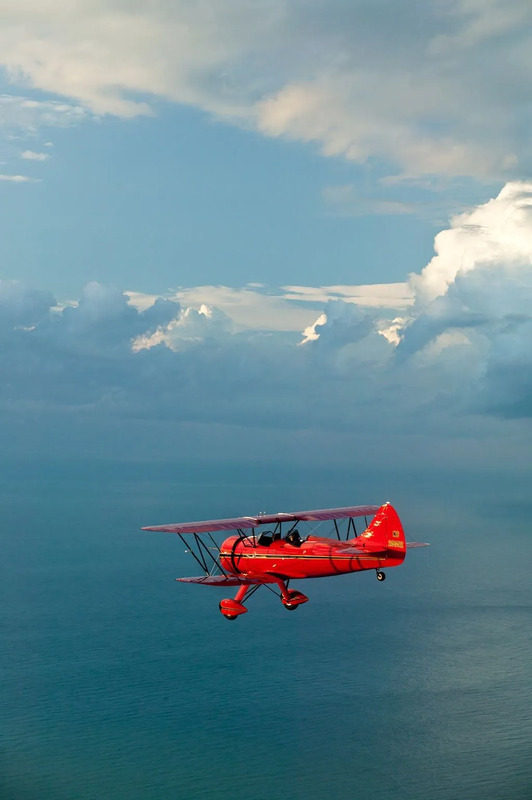 an airplane flying over the ocean on a cloudy day