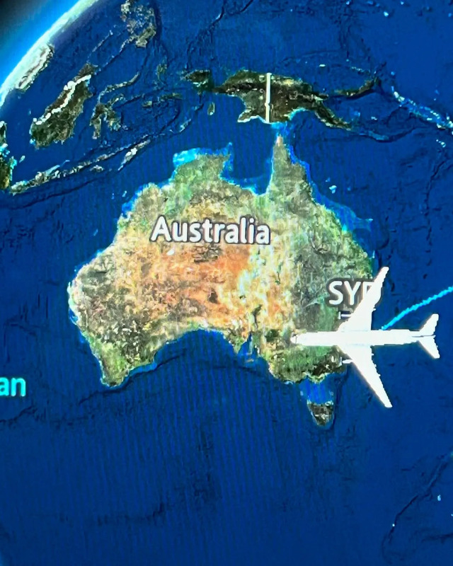 an airplane is flying over the earth with australia on it's side and another plane in the background