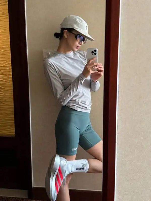 a woman is taking a selfie in front of a wall with her cell phone
