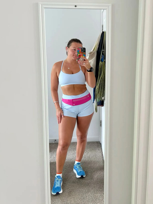 a woman taking a selfie in the mirror with her cell phone and running shoes