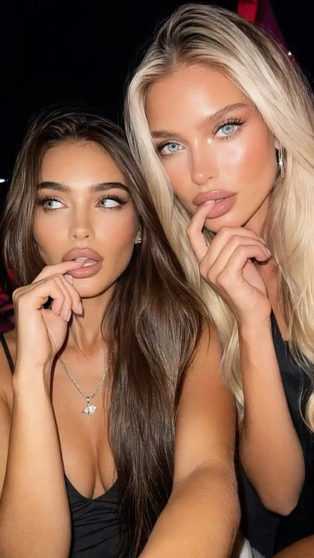 two beautiful women sitting next to each other with their hands on their chins and looking at the camera