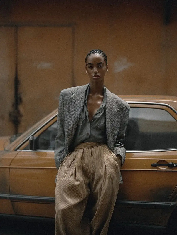 a woman standing next to a brown car