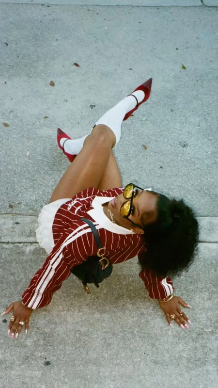 a woman laying on the ground with her legs spread out and wearing red and white clothes