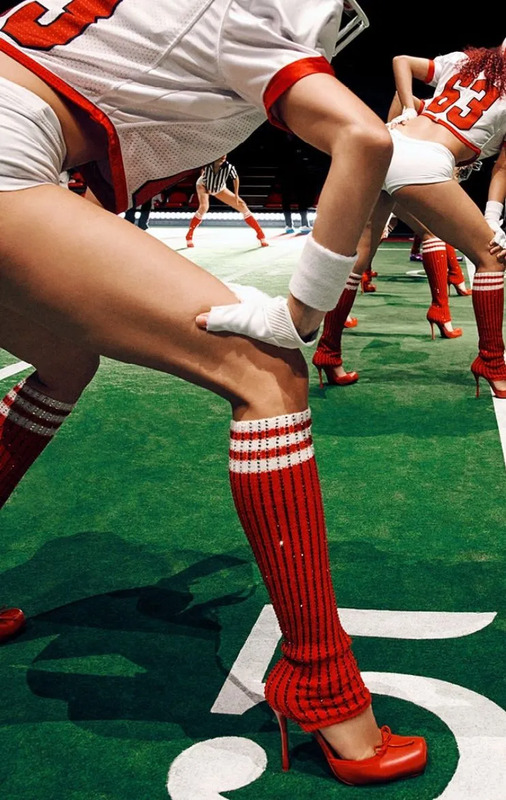 the legs and feet of cheerleaders in short shorts, knee socks and high heels