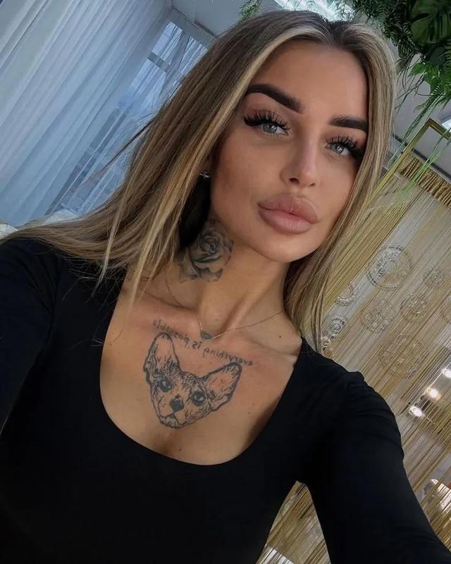 a woman with tattoos on her chest posing for the camera