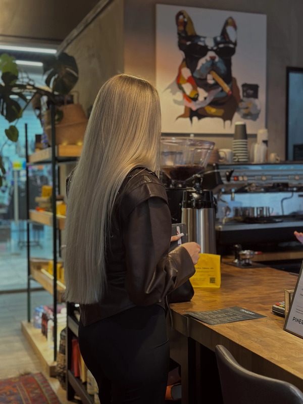 a woman with long blonde hair sitting at a counter