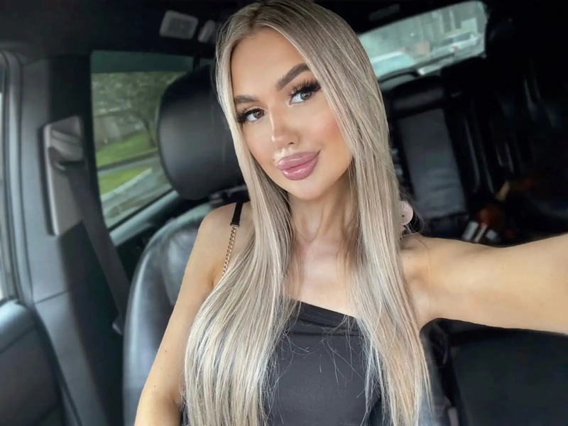 a woman sitting in the back seat of a car with her hand on her hip