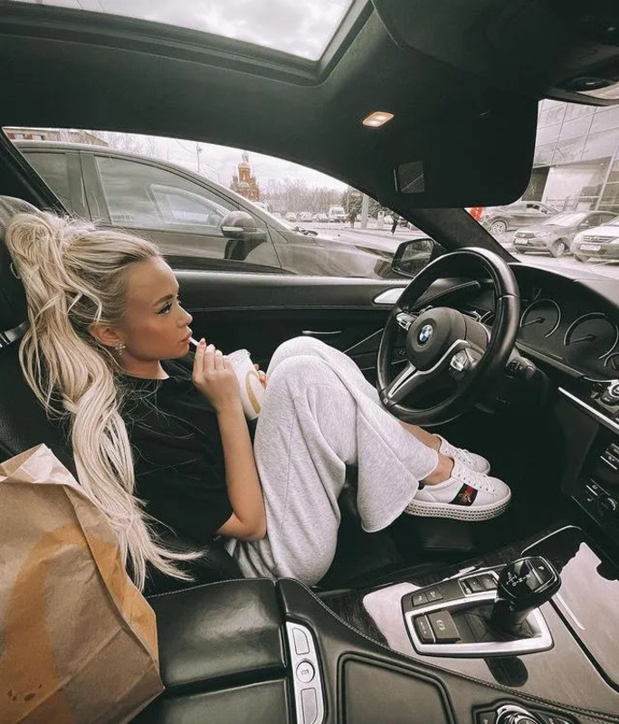 a woman sitting in the driver's seat of a car