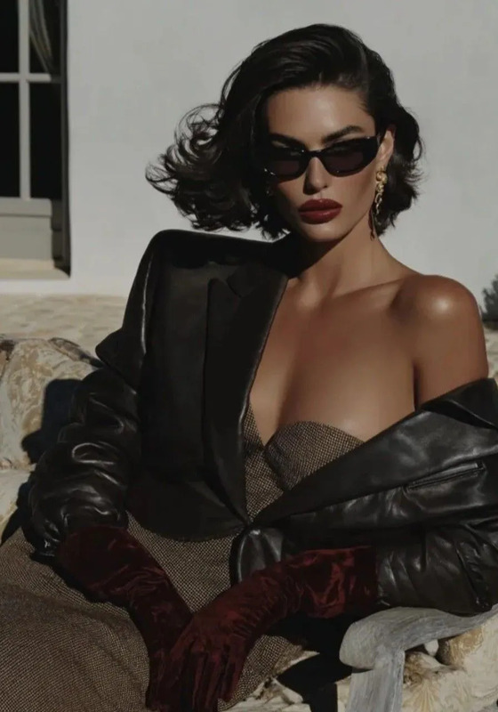 a woman sitting on top of a couch wearing sunglasses