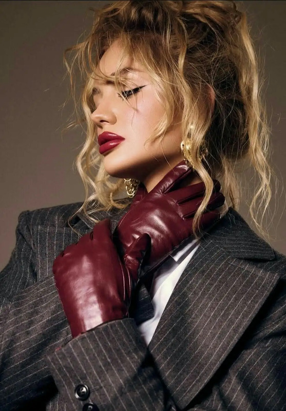 a woman in a suit and red gloves