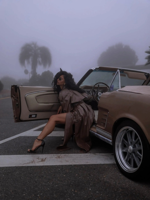 a woman sitting on the back of a car