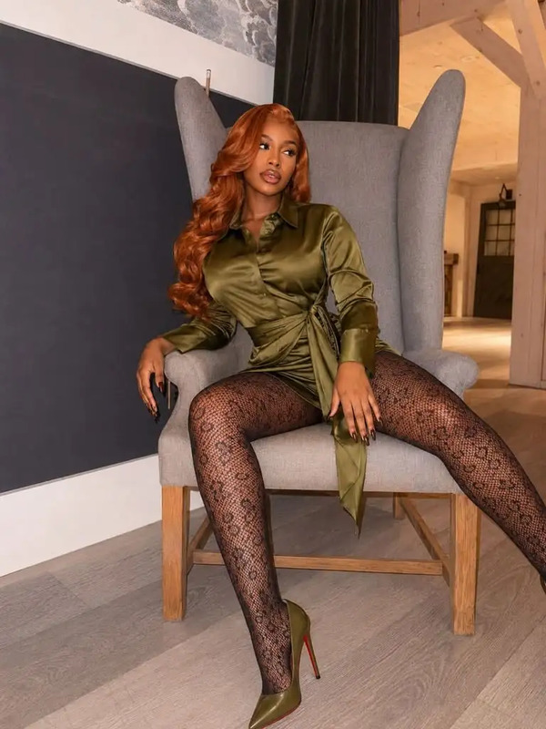 a woman sitting in a chair with her legs crossed and wearing fishnet tights