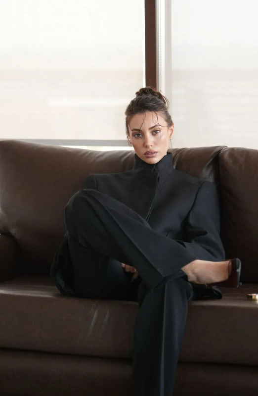 a woman sitting on top of a brown couch