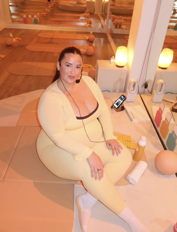 a woman sitting on top of a table next to an egg wearing a headset