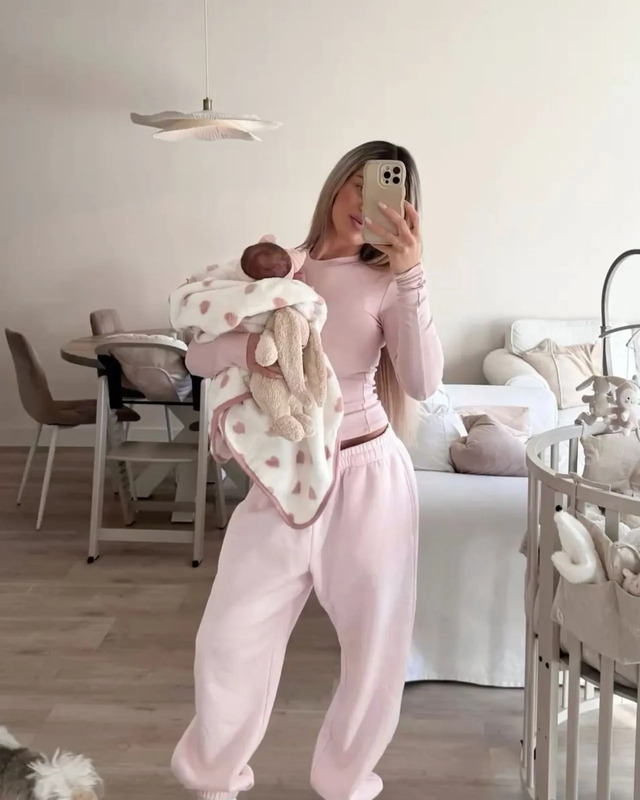a woman taking a selfie while holding a baby in her arms and looking at the camera