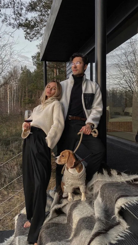 a man and woman standing next to each other with two dogs on their leashes