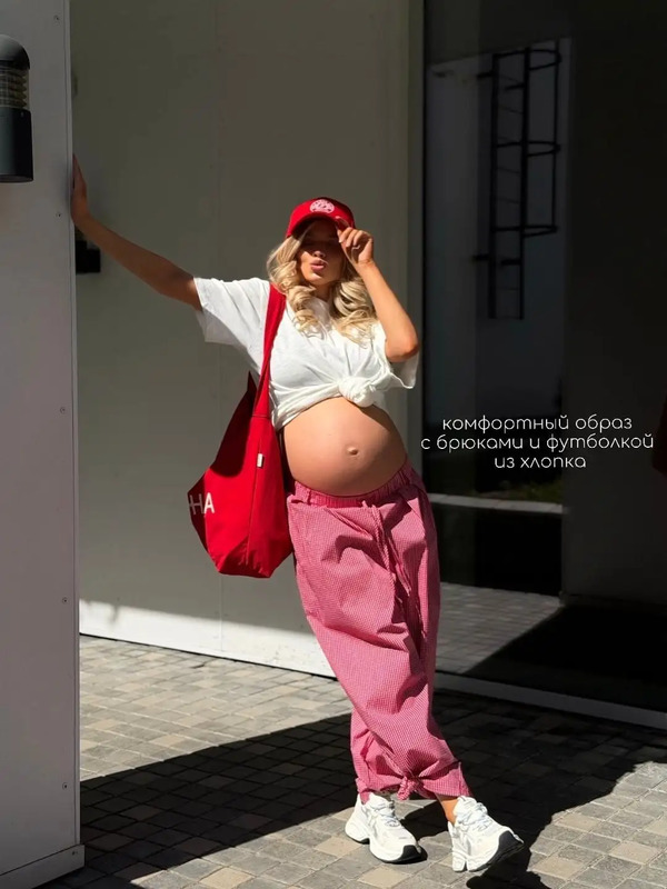 a pregnant woman in pink pants and white shirt