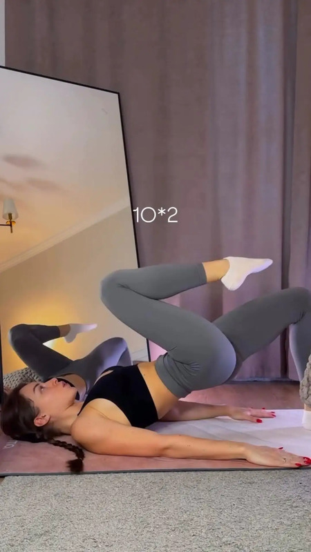 a woman laying on the floor in front of a mirror with her legs spread out