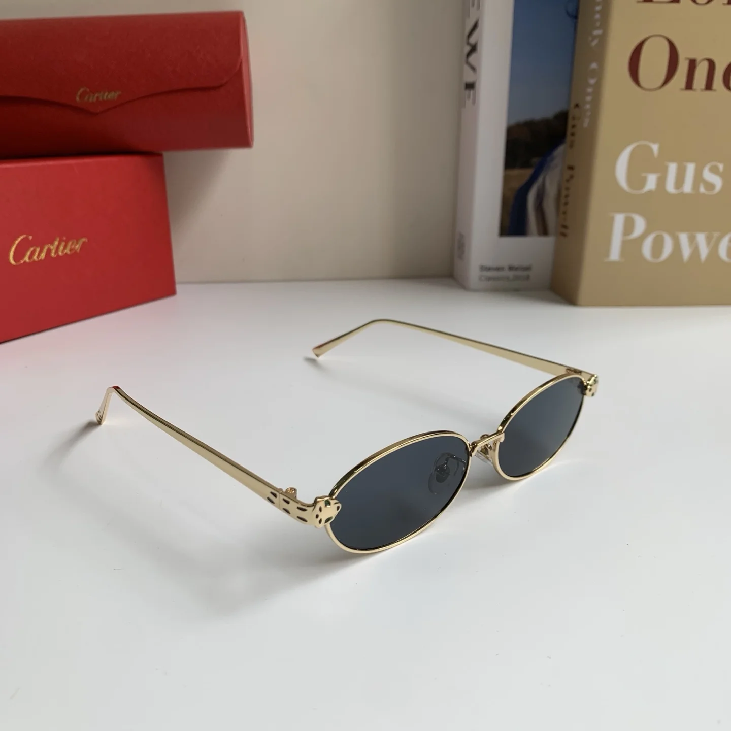 Солнцезащитные очки с овальной золотистой оправой и темными линзами