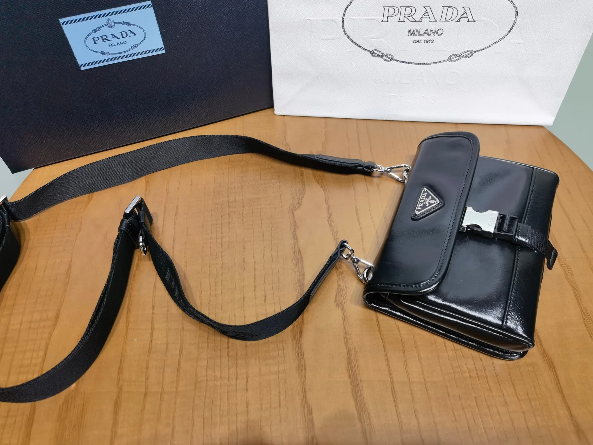 Мини-сумка Prada из черной маслянистой кожи через плечо
