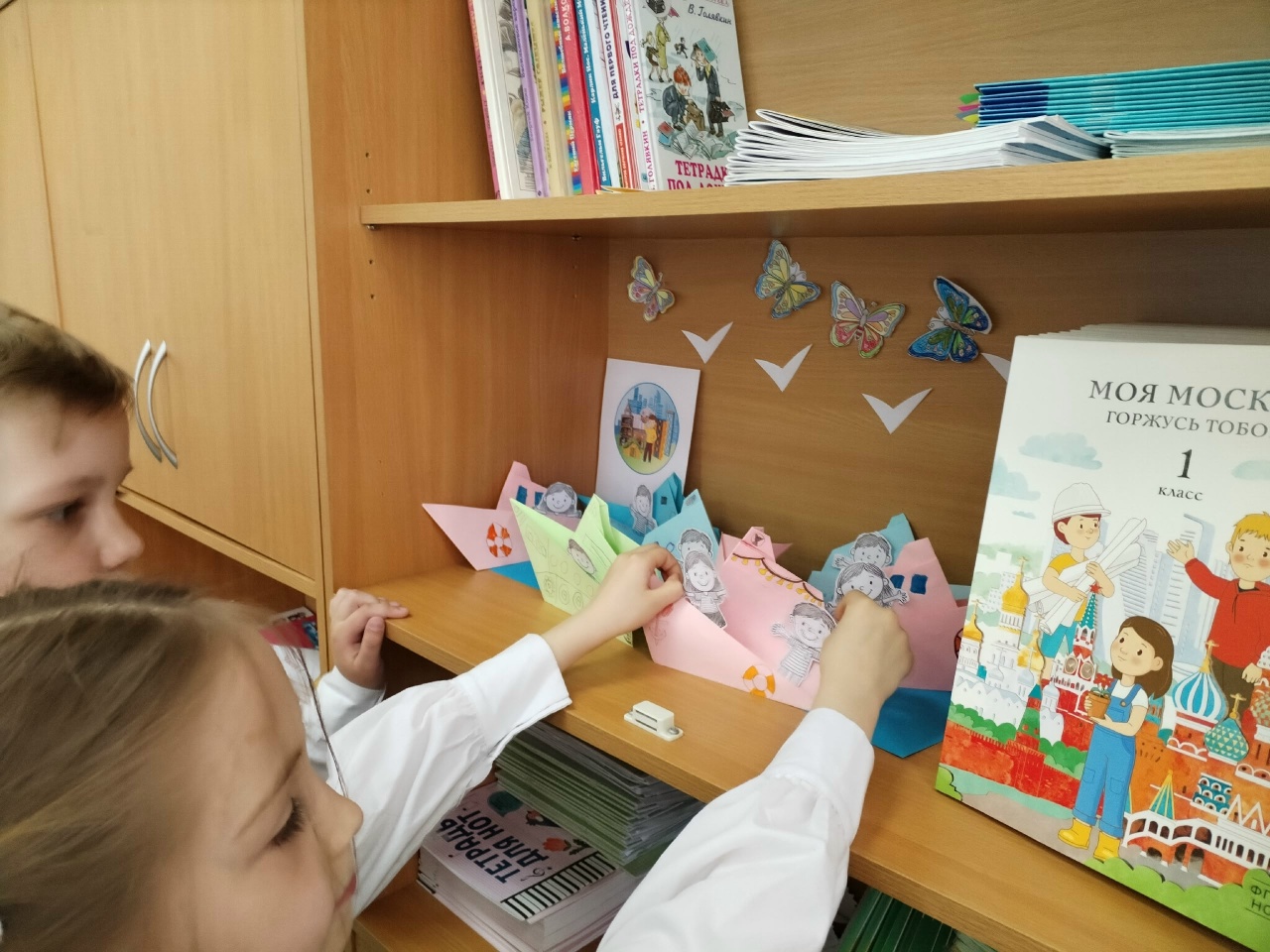 В классе есть специальное место для работ учащихся, выполняемых в рамках курса "Моя Москва". В конце урока ребята размещают свои работы. Очень часто просят забрать их домой, чтобы показать родным, поэтому выставка длится не более 5 минут.